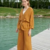 A dark yellow waffle-like textured linen jacket with a belt paired with matching wide leg linen trousers