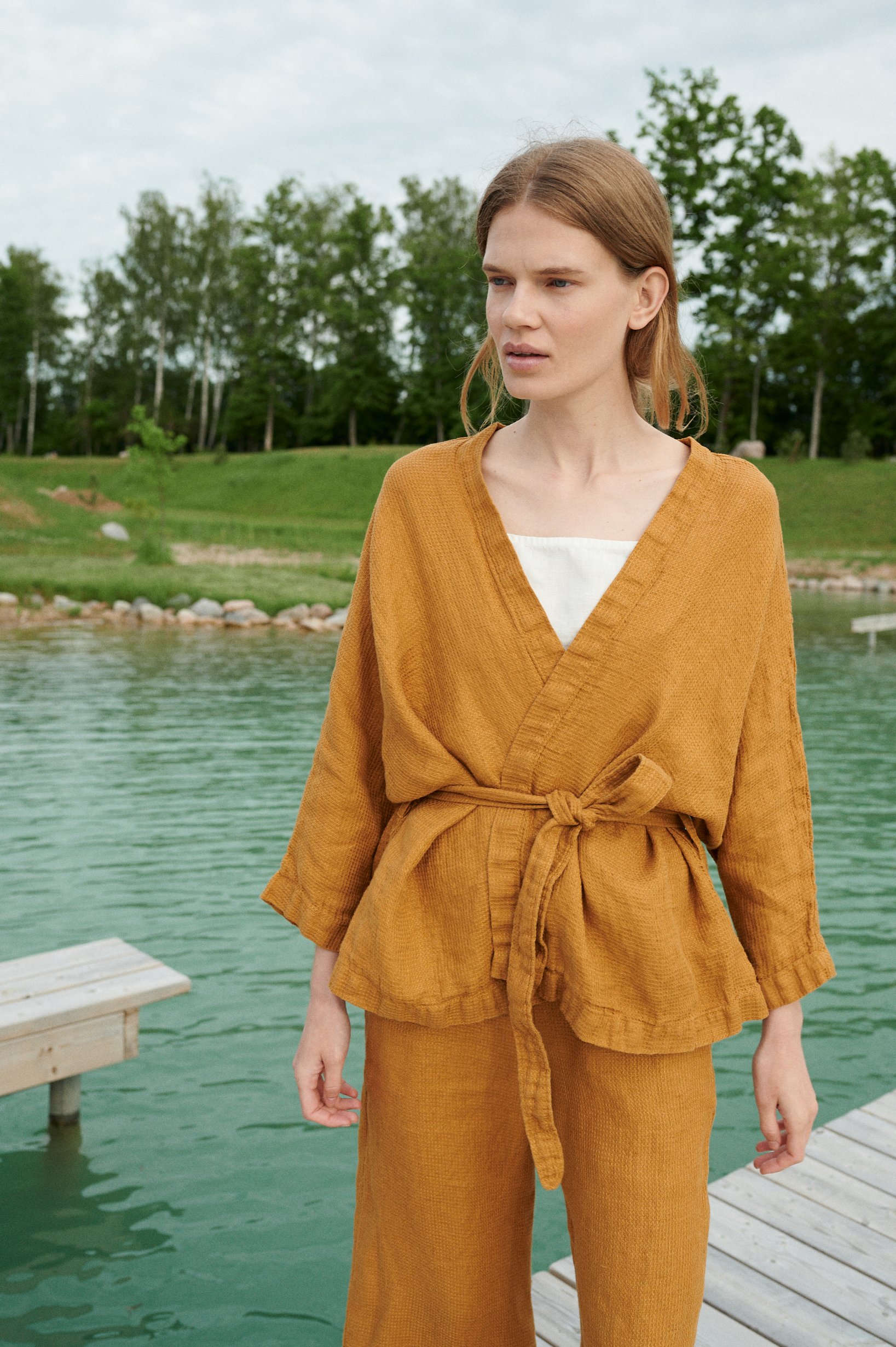 Model in an oversized waffle-like textured linen jacket with a belt