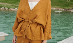 A kimono-style linen jacket worn with a matching belt and wide leg linen trousers