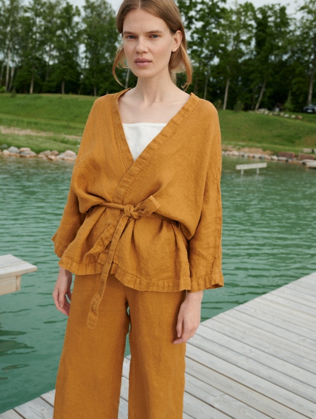 A kimono-style linen jacket worn with a matching belt and wide leg linen trousers