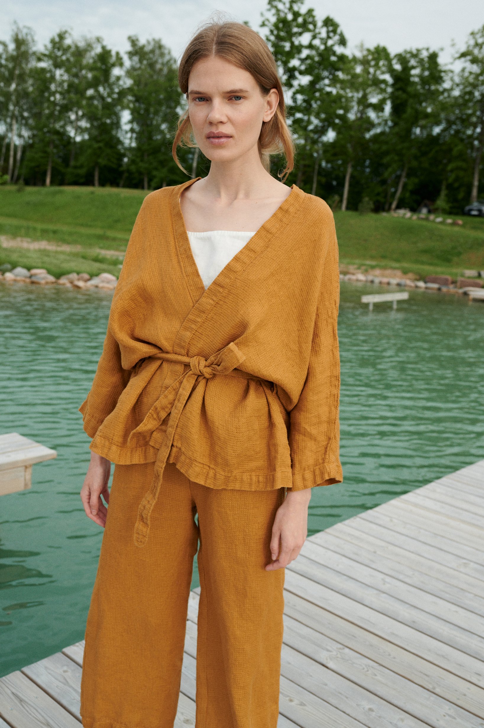 A kimono-style linen jacket worn with a matching belt and wide leg linen trousers