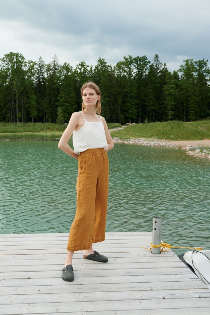 A model standing in deep yellow waffle linen trousers