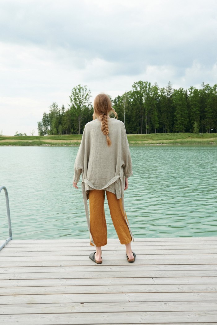 Back of a model in an oversized waffle linen jacket and cropped linen trousers