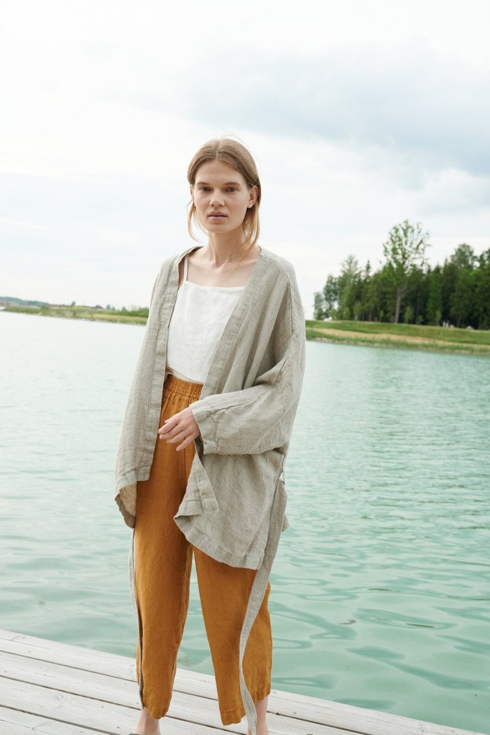 Model wearing an oversized kimono-style jacket untied paired with loose fitting linen trousers
