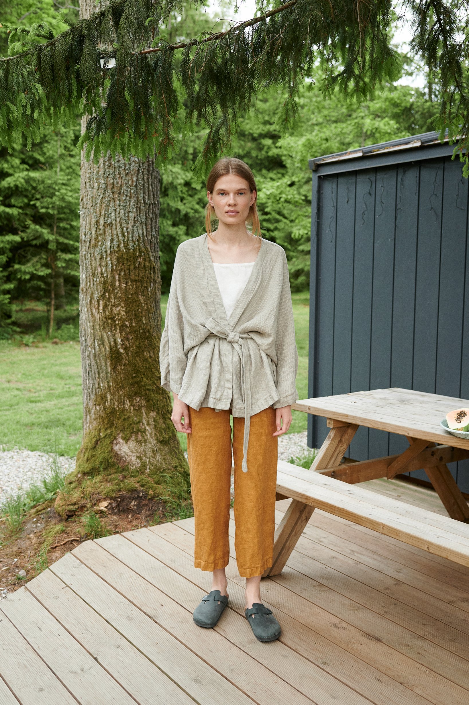 Woman in an oversized kimono-style waffle linen jacket and loose-fitting linen trousers outfit
