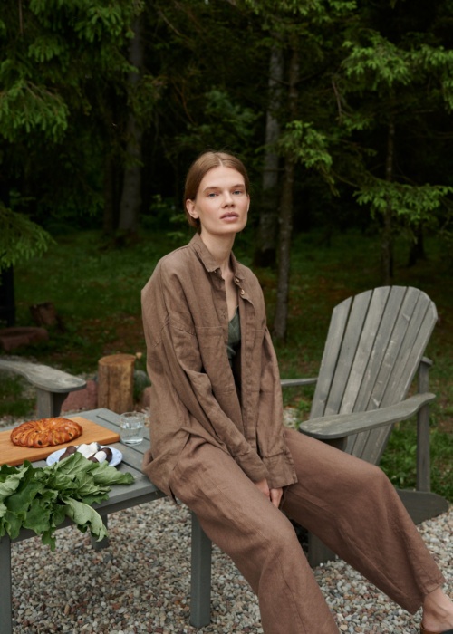Model in a loose-fitting waffle linen button down shirt and matching linen trousers outfit