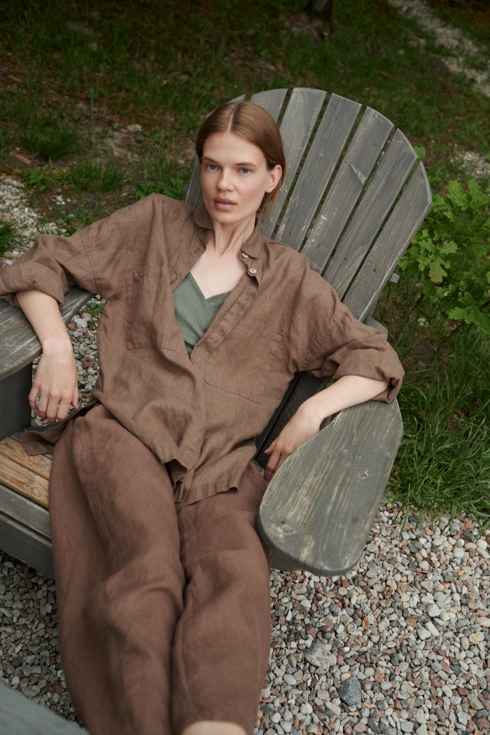 A woman sitting in brown oversized linen shirt