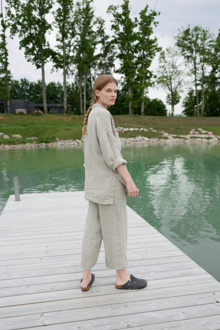A woman wearing waffle linen wide leg trousers in natural grey