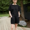 Model in an oversized black linen top and matching linen shorts