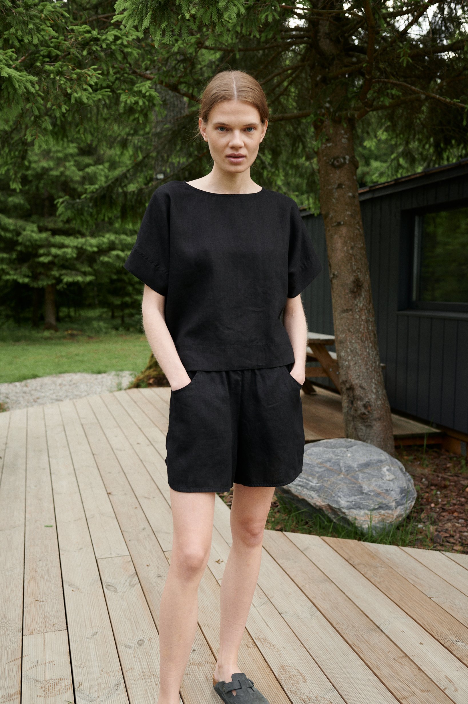 Model in an oversized black linen top and matching linen shorts