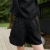 An elasticated waistband of linen shorts with pockets