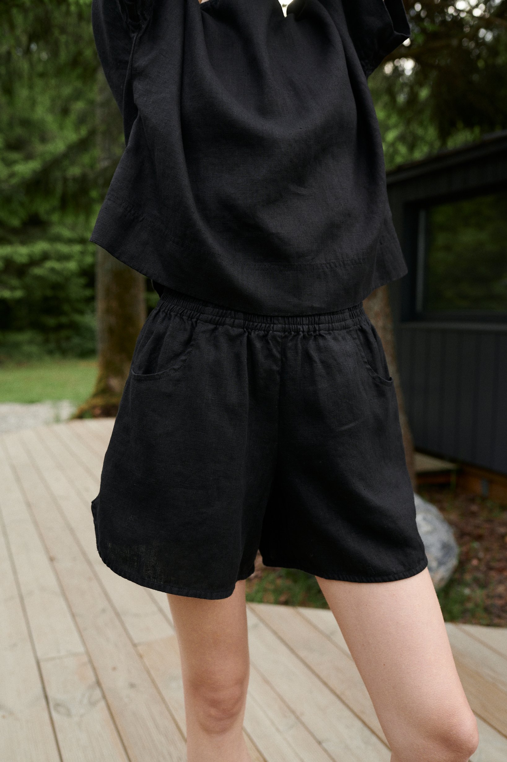 An elasticated waistband of linen shorts with pockets