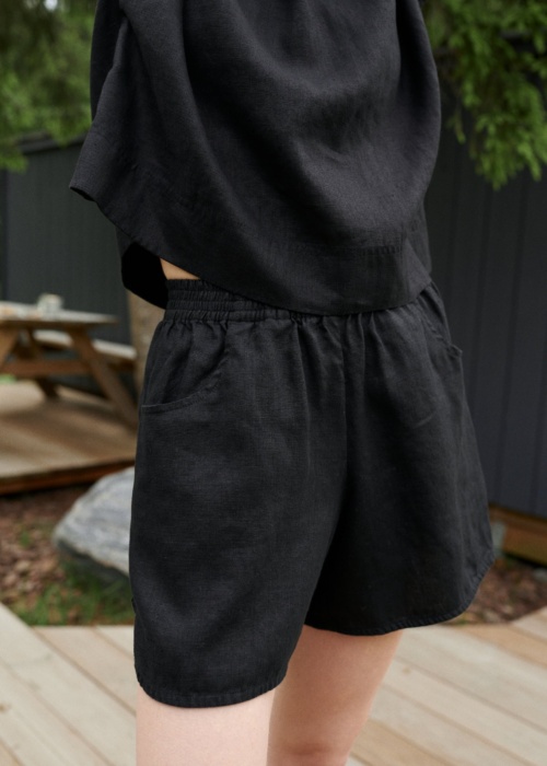 Black linen shorts with an elasticated waistband and pockets