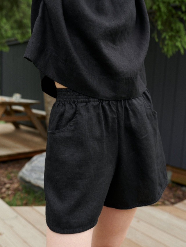 Black linen shorts with an elasticated waistband and pockets