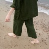 A woman wearing waffle linen wide leg trousers in dark green