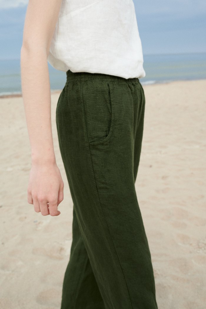 Dark green waffle linen trousers on a model