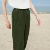 A woman wearing dark green wide leg trousers from waffle linen
