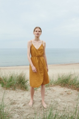 A flowy waffle linen summer dress with thin straps and a curved hem
