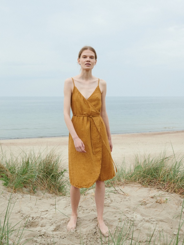 A flowy waffle linen summer dress with thin straps and a curved hem