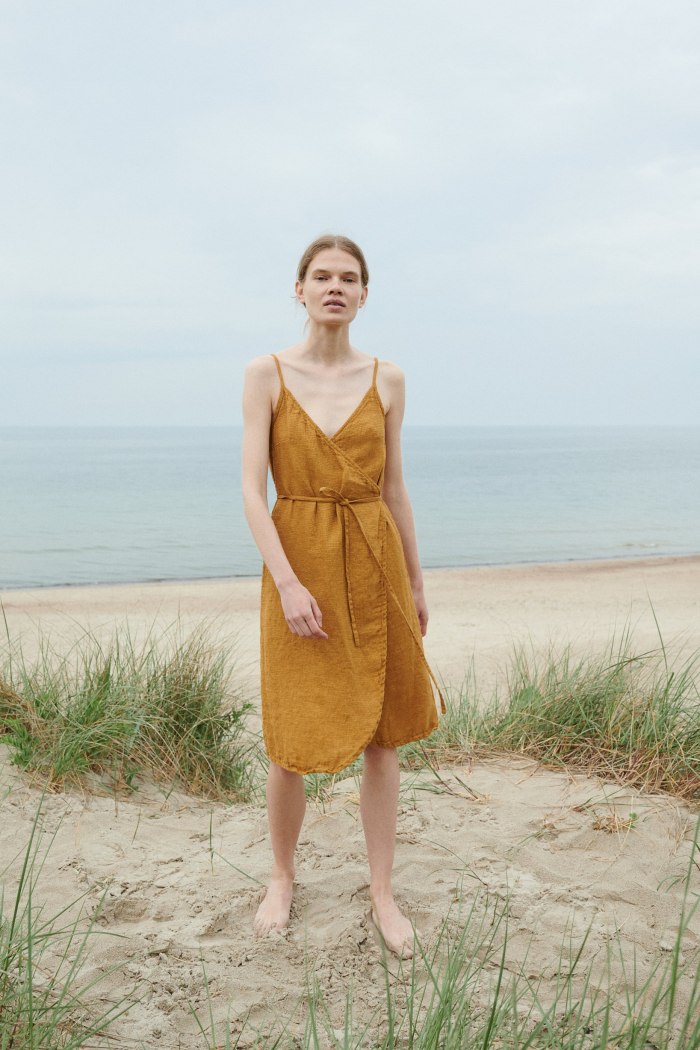 A flowy waffle linen summer dress with thin straps and a curved hem