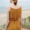 Back of a woman wearing a dark yellow color waffle linen summer dress