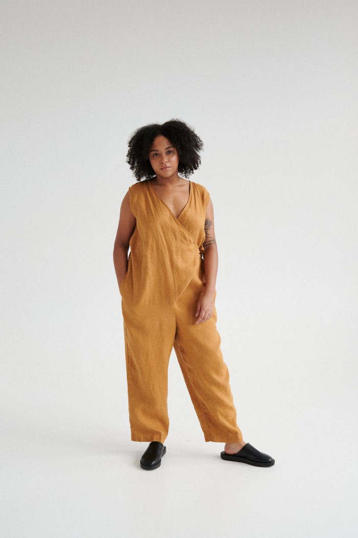 Woman wearing a loose-fitting linen jumpsuit with a wrap top part and side pockets