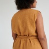 Back of an oversized linen jumpsuit tied with a belt