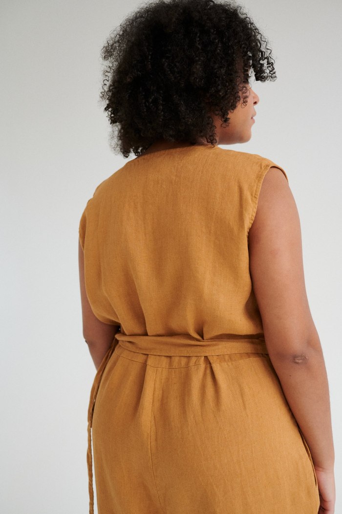 Back of an oversized linen jumpsuit tied with a belt