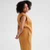 Side view of a model in an oversized linen jumpsuit with pockets