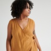 An oversized sleeveless linen jumpsuit with a wrap top part