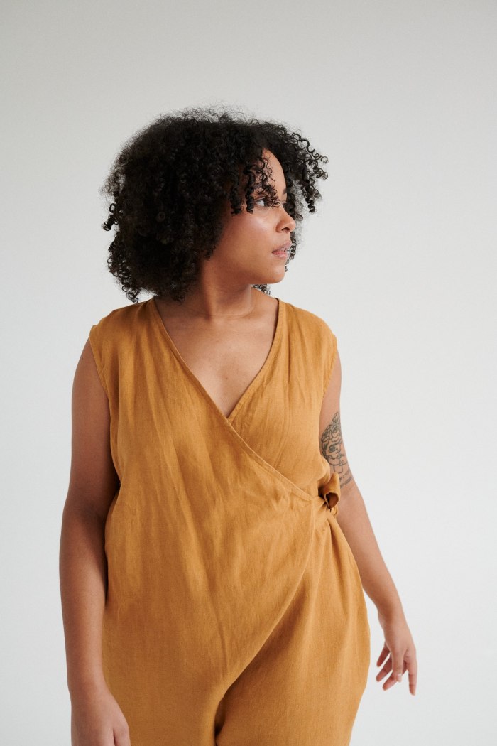 An oversized sleeveless linen jumpsuit with a wrap top part