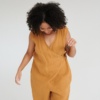 Model in an oversized dark yellow linen jumpsuit with a wrap upper part