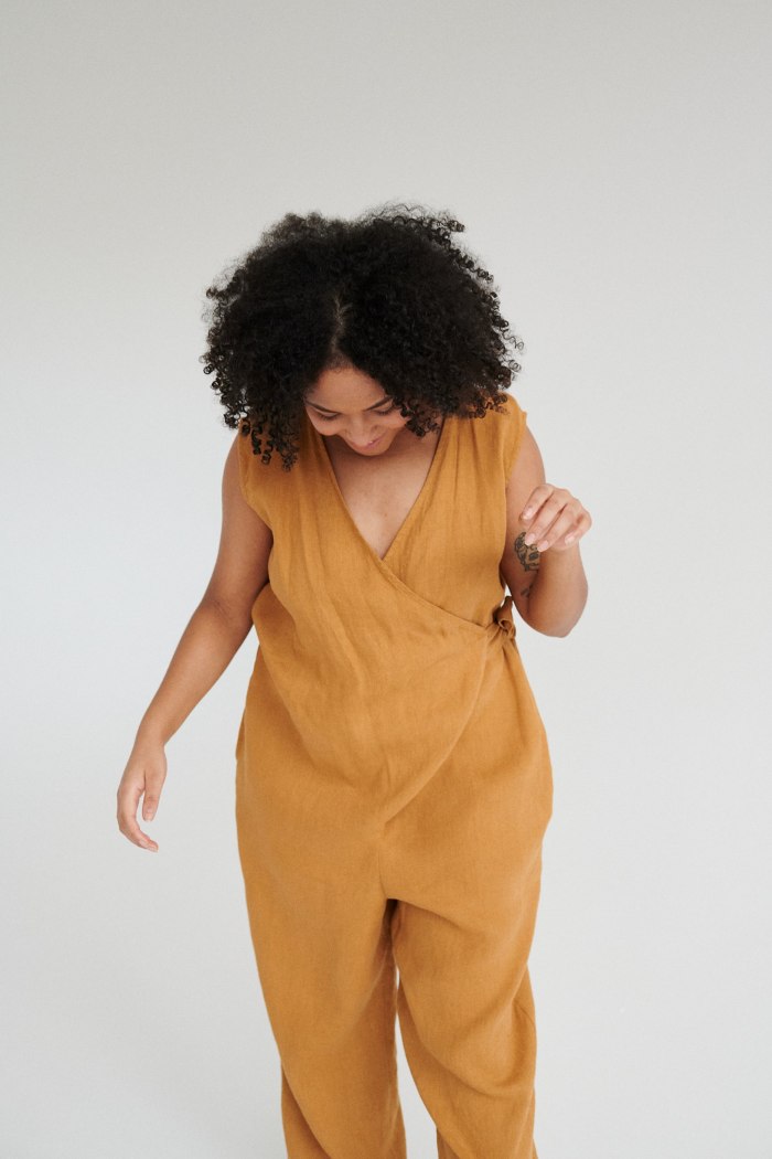 Model in an oversized dark yellow linen jumpsuit with a wrap upper part