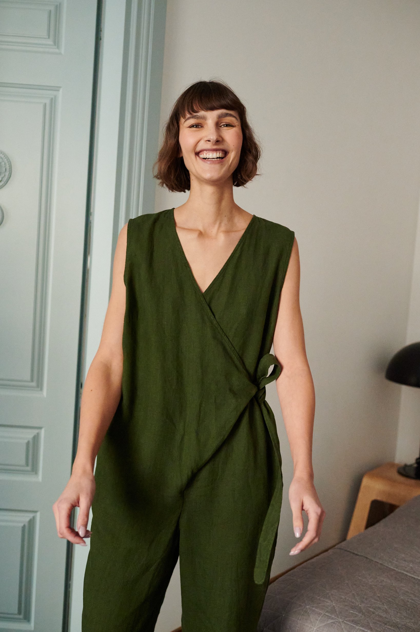 Dark green oversized linen jumpsuit with a wrap upper part and a V-neckline