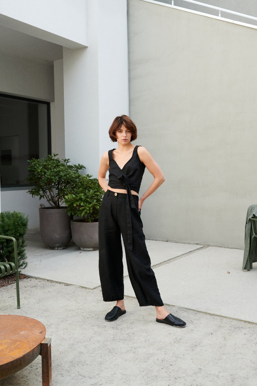 A french model in heavy linen black wide leg trousers