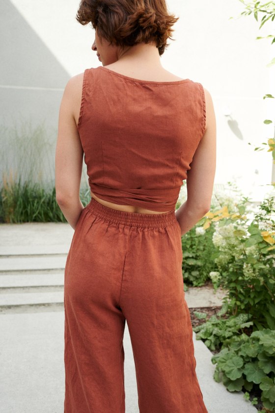 Back of a cropped wrap linen top paired with high-waisted linen pants