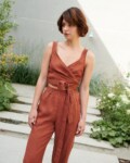Model wearing a terracotta cropped linen top with matching high-waisted linen trousers