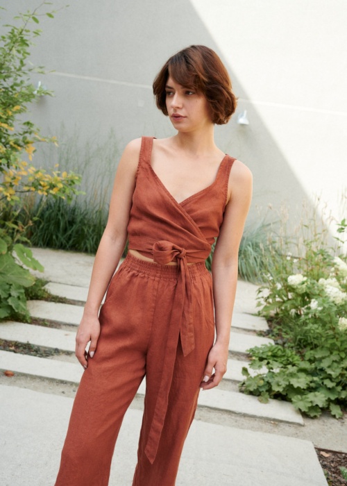 Model wearing a terracotta cropped linen top with matching high-waisted linen trousers
