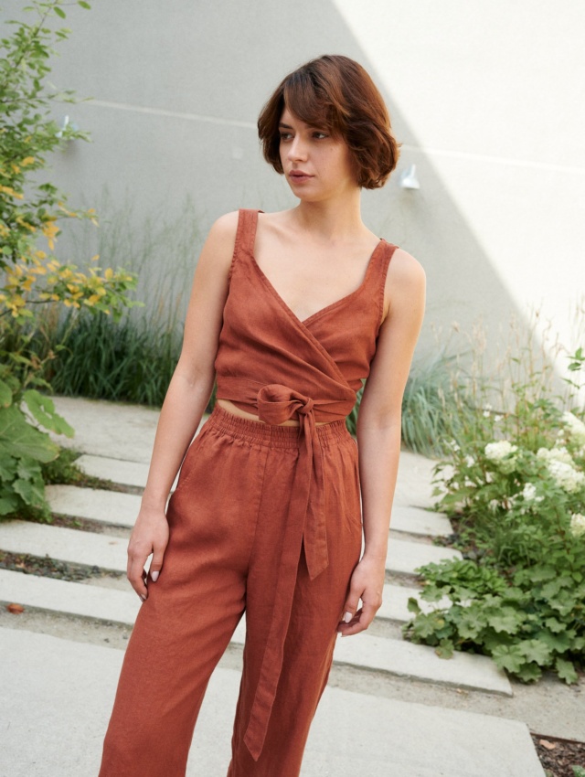 Model wearing a terracotta cropped linen top with matching high-waisted linen trousers