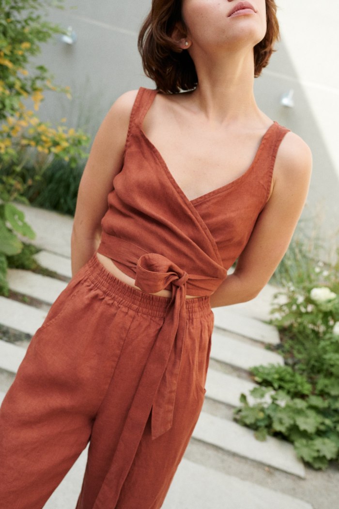 A terracotta wrap linen top and loose-fitting linen trousers outfit