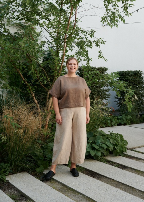 A woman standing in beige natural linen wide leg trousers