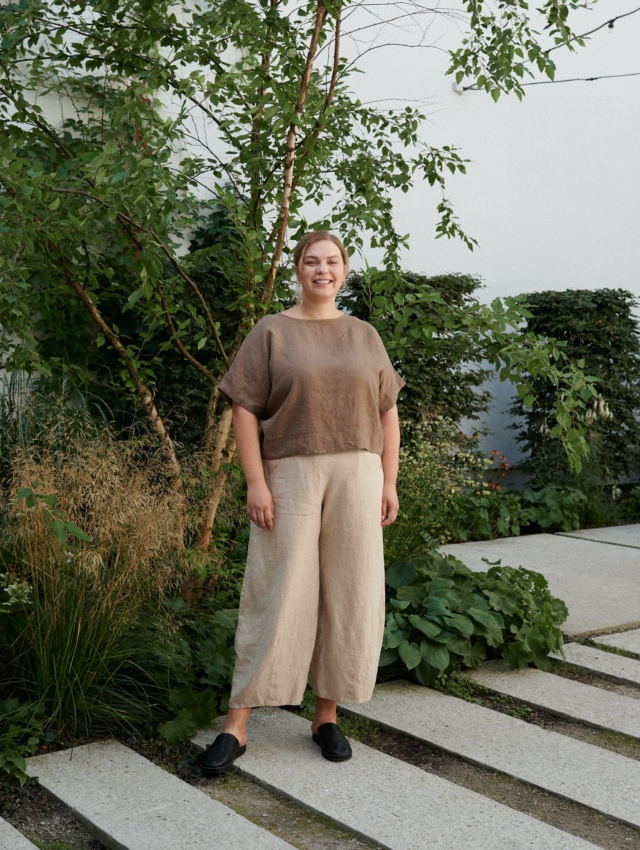 A woman standing in beige natural linen wide leg trousers