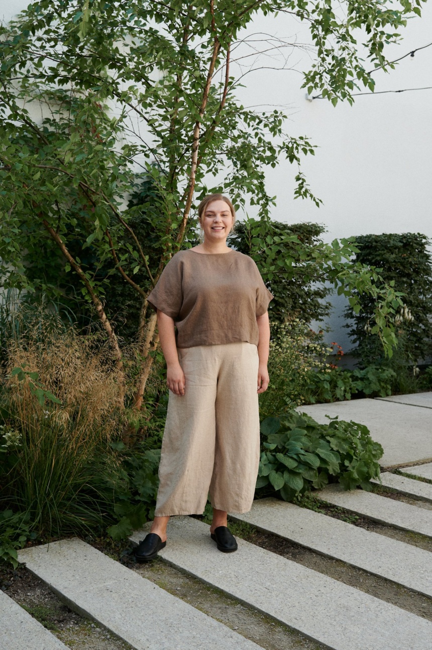 A woman standing in beige natural linen wide leg trousers