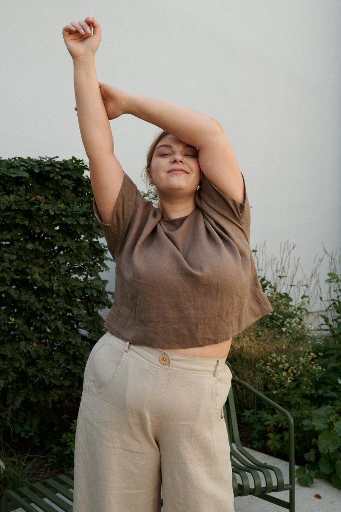 A woman wearing high waist beige linen pants