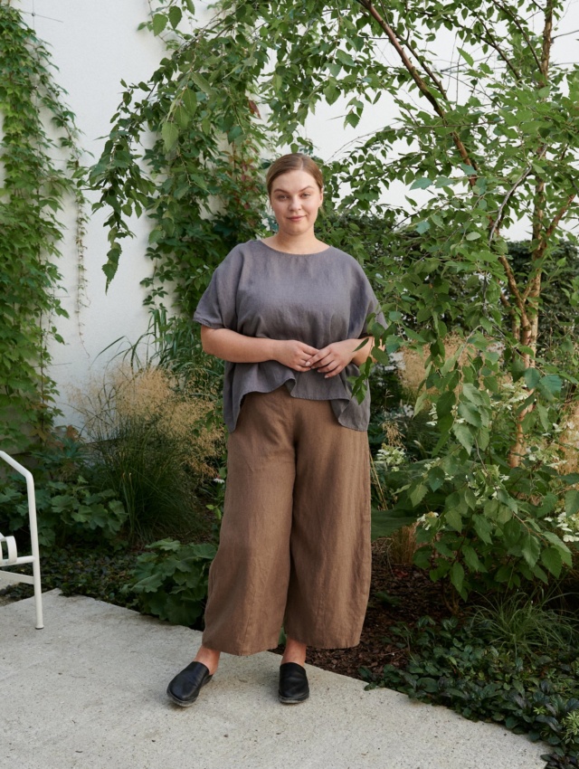 A woman standing in brown natural linen trousers in brown