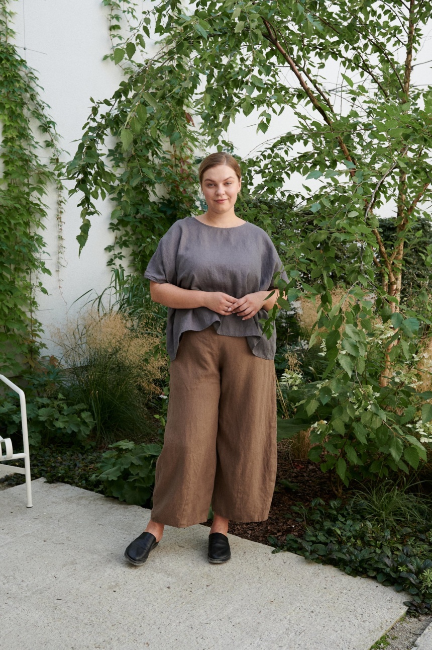 A woman standing in brown natural linen trousers in brown