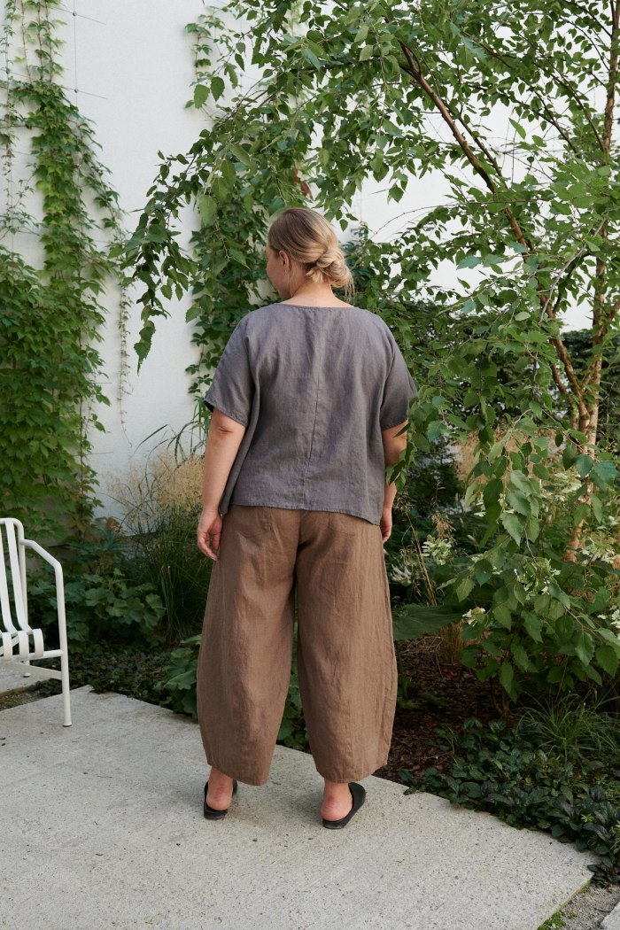 Woman's back wearing brown linen wide leg trousers