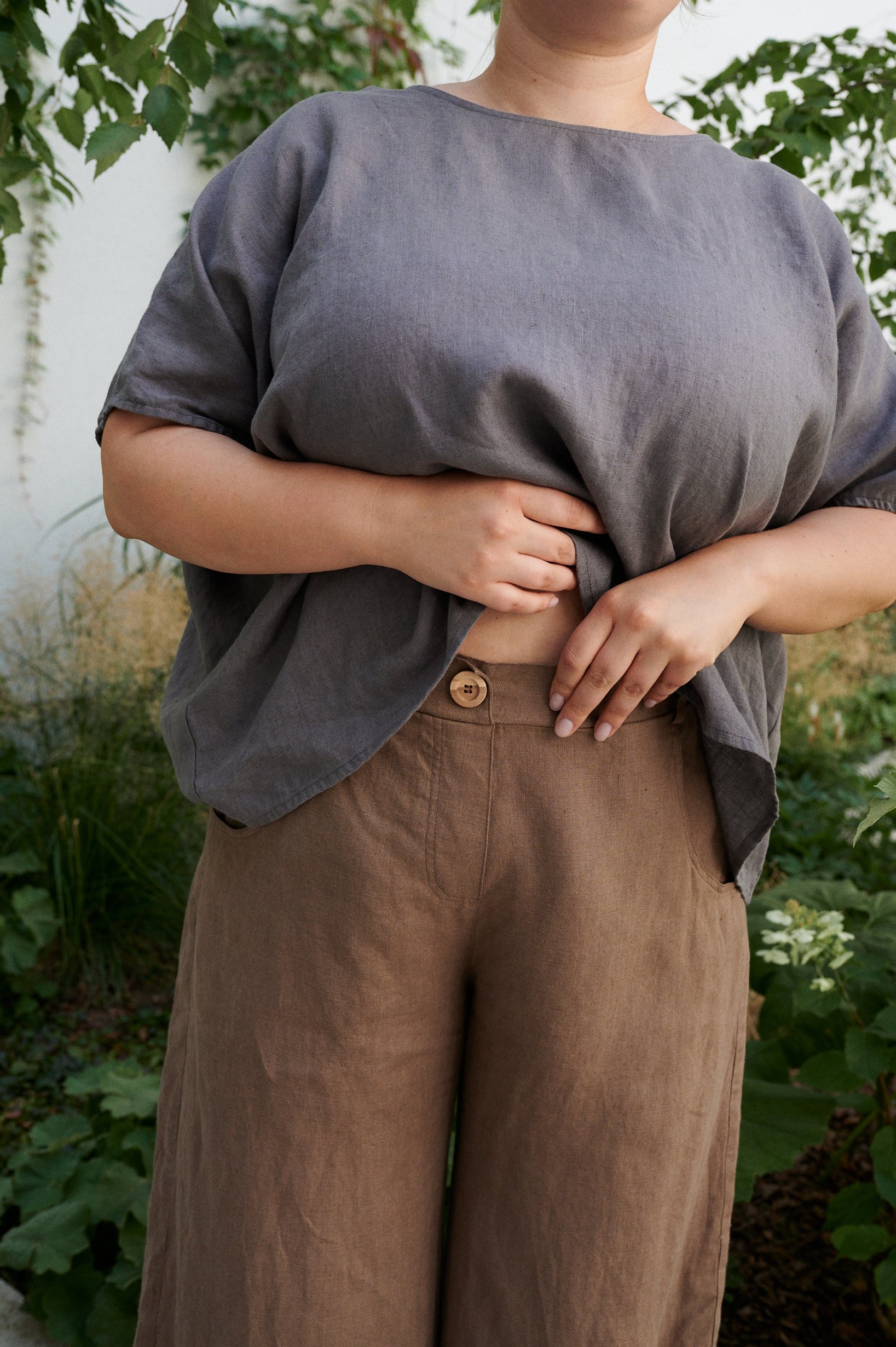 A decorative button of high waist linen trousers in brown