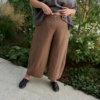 A woman wearing high waist linen brown pants