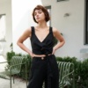 A model in heavy linen black barrel trousers and a matching wrap top